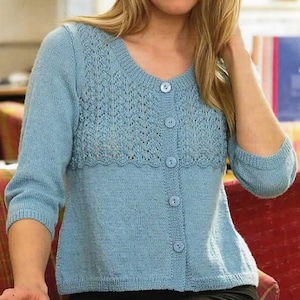 Könnte beinhalten: Hellblauer Strickcardigan mit rundem Ausschnitt und Knopfverschluss. Der Pullover hat ein dekoratives Spitzenelement auf der Brust und Dreiviertelärmel. Der Cardigan ist aus weichem, bequemem Strick gefertigt.