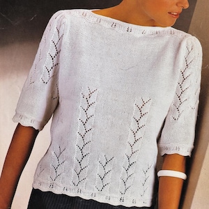 May include: A white knitted top with short sleeves and decorative leaf-shaped cutouts. The top has a boat neck and a bust size of 81-97 cm. The image also includes the text "4 PLY" and measurements in inches.