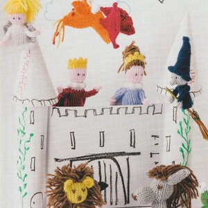 May include: A knitted castle scene featuring a king, queen, angel, witch, and lion. The castle has a drawbridge and is decorated with green vines. The characters are made of yarn in various colours. The scene evokes a fairytale or children's story.