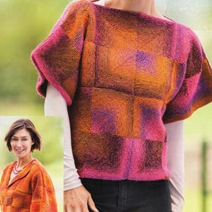 May include: A knitted top in a patchwork design, featuring squares of orange, pink, and purple. The top has short sleeves and a wide neckline. The model is wearing a white long-sleeve shirt underneath and black jeans.