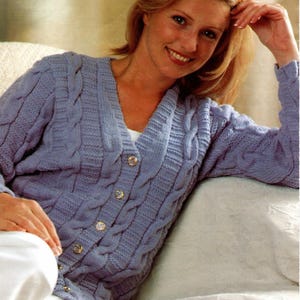 以下が含まれることがあります： Vネックと長袖のライトブルーのケーブルニットカーディガン。 金色のボタンが付いたボタンダウンフロント。 カーディガンは柔らかく、質感のある素材で作られています。