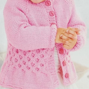 May include: A light pink long-sleeved knit cardigan featuring a round neckline, a button-down front with five matching pink buttons, and a textured honeycomb-style stitch pattern on the lower section of the garment body and sleeves.