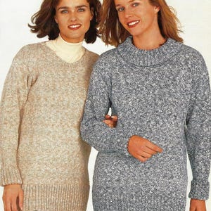 Può includere: Due donne con maglioni di lana. Uno è beige chiaro con scollo a V, l'altro è un maglione grigio screziato con collo a imbuto. Entrambi i maglioni hanno maniche lunghe e polsini e orli a coste. Le donne sorridono.