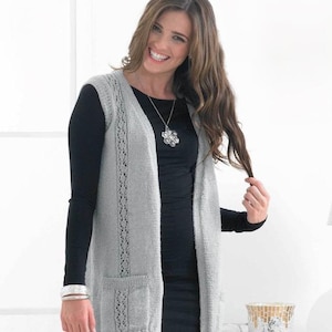 Puede incluir: Un chaleco de punto gris claro con cuello en V, bolsillos y paneles calados decorativos. El chaleco se lleva sobre una camiseta negra de manga larga y un vestido negro. El chaleco tiene un ajuste relajado y está hecho de un hilo suave y texturizado.