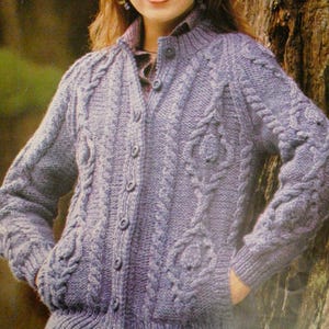 Peut inclure: Un cardigan en tricot de câble violet clair avec un col montant et des poches. Le pull présente des motifs de câbles complexes et est fait d'un fil doux et texturé. Le cardigan est un style classique, idéal pour superposer par temps frais.