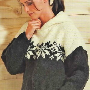 May include: A hooded sweater in ivory, charcoal, and black. The upper portion is ivory, with a black and white floral design across the chest. The sleeves and lower portion are charcoal. The sweater is made of a soft, textured material.