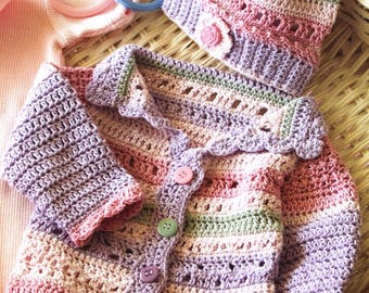 May include: A handmade crochet baby set in pastel colors, including a hat and cardigan. The cardigan has a scalloped edge, button closure, and long sleeves. The hat features a small flower accent. The set is made with pink, purple, and green yarn.