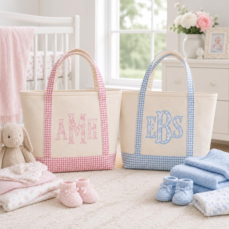 May include: Two canvas tote bags with gingham trim and embroidered monograms. One bag features pink gingham trim and the letters AMH in pink floral embroidery. The other bag features blue gingham trim and the letters EBS in blue floral embroidery.