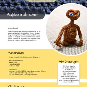 K&ouml;nnte beinhalten: Geh&auml;kelte braune Alien-Figur mit gro&szlig;en blauen Augen, kleinem Mund und langen Fingern. Die Figur ist ca. 11 cm gro&szlig;. Das Bild enth&auml;lt auch Text auf Deutsch.