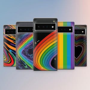 May include: Five phone cases with colourful designs are displayed. The cases showcase patterns such as a rainbow, a heart, and abstract swirls. Each case has a black camera bar.