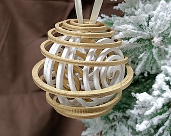 May include: A white and gold spiral Christmas ornament with a white ribbon hanging from the top.
