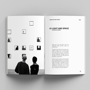 May include: Two people stand in front of a wall with black and white framed photographs. The photographs are of different sizes and shapes. The text on the page reads "ARCHITECTURE STUDIES 01 LIGHT AND SPACE Architecture Studies Odeon est qui cola dolum quon est officiendiis adit anhilist, sequ aut andpsa dunt. Volentia poriam above innumquodam vidento cus dolla abore me humodiat eum nesto etuandentias ut fugian, quam felica qui dolorum aut sande volun quam as sperunt quentem laud alcor quien bila doloretum lauda volor alcu bien ide dolopter aude duium. Adamutautitha drutius duololemet etur era denitas doluptat con-noverque dequia tempoluptas voluptur aut reium quias perfericid que harumquas aut expe dolla aut vellavoloan num et eos et dolore per rehat quod etur a num ef libus, od quberon iditat undeligen."