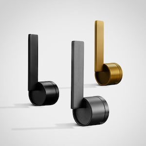 May include: Three modern door handles in black, gray, and gold. Each handle features a rectangular vertical bar connected to a cylindrical base. The handles are designed with a minimalist aesthetic.