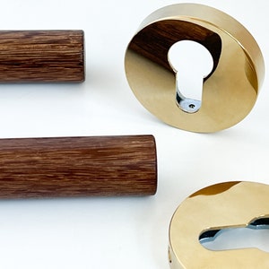 May include: Two wooden dowels and two gold metal door knob escutcheons with keyhole cutouts.