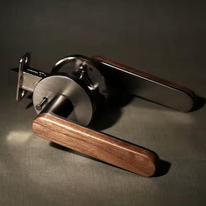 May include: A modern door handle with a brushed nickel finish and a wooden accent. The handle has a simple, minimalist design.