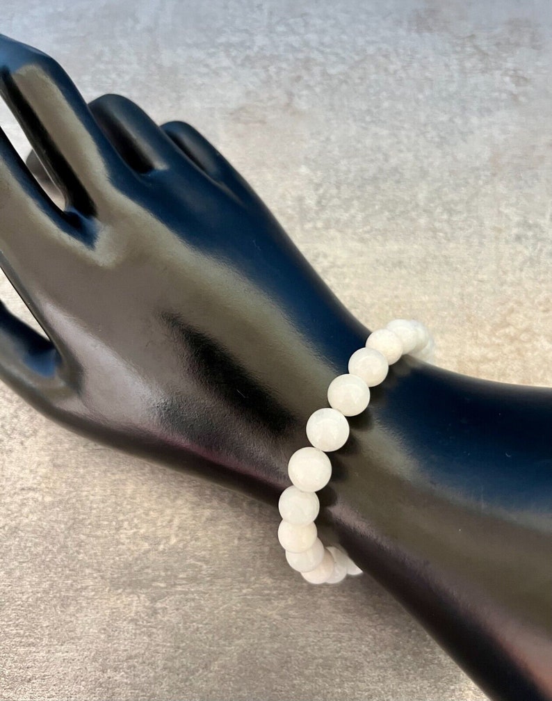 May include: White gemstone bracelet with round beads.