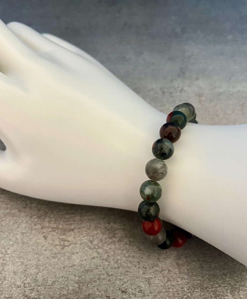 K&ouml;nnte beinhalten: Ein Armband aus gr&uuml;nen, roten und schwarzen Edelsteinperlen.