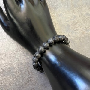 May include: A black beaded bracelet made of labradorite stones.