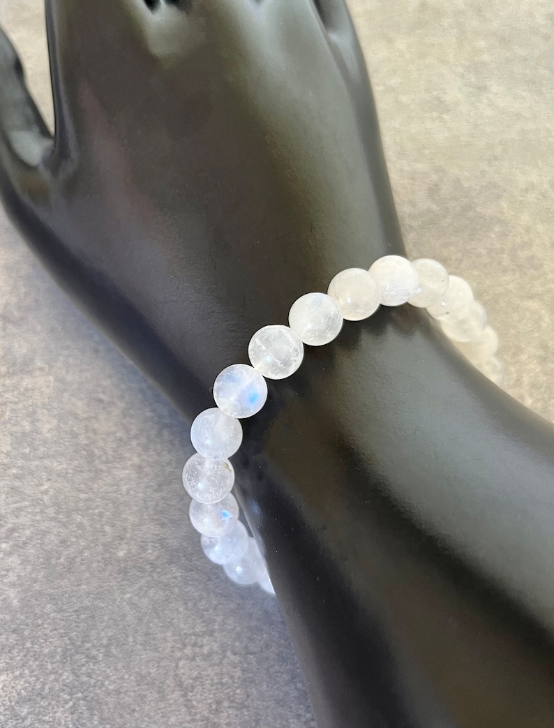 May include: A white moonstone beaded bracelet with a stretchy elastic band.