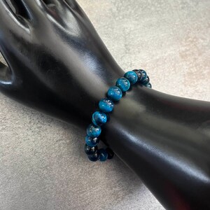 May include: A blue tiger's eye beaded bracelet. The bracelet is made of round beads and is strung on elastic.
