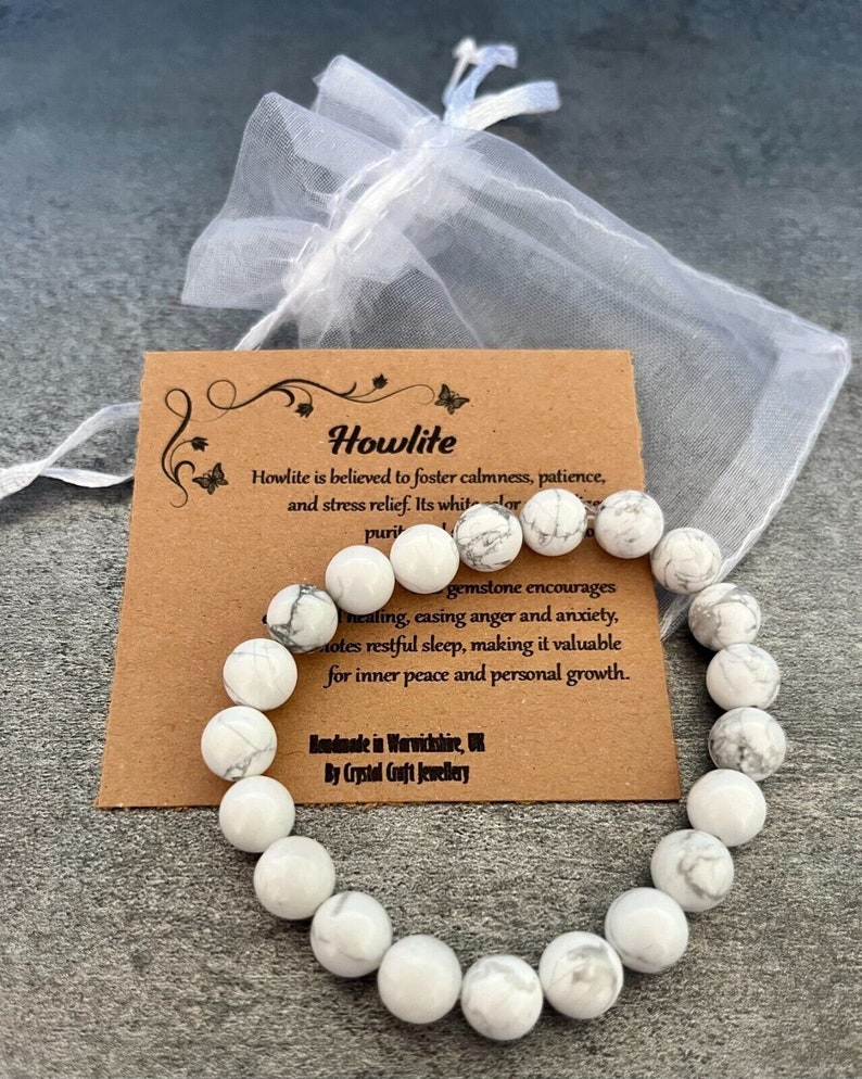 May include: White howlite gemstone bracelet with gray veining. The bracelet is made of round beads and is packaged in a white organza bag. The card reads "Howlite is believed to foster calmness, patience, and stress relief. Its white color encourages healing, easing anger and anxiety, promotes restful sleep, making it valuable for inner peace and personal growth. Handmade in Warwickshire, UK by Crystal Craft Jewellery."