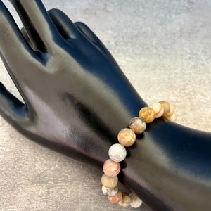 May include: A bracelet made of brown, white, and orange agate beads.
