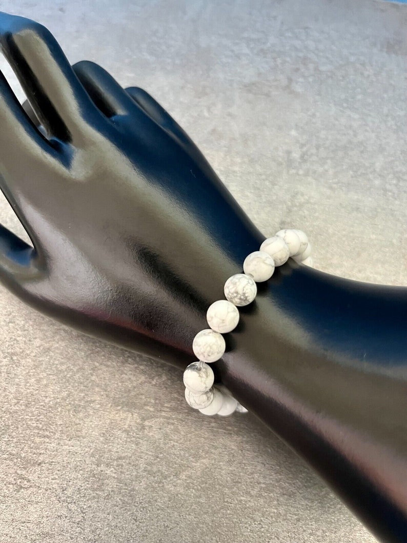 May include: White howlite beaded bracelet with a stretchy elastic band. The beads are round and have a marbled pattern.