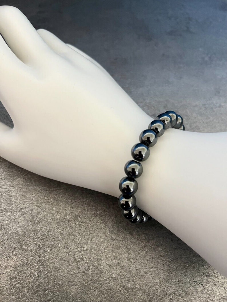 May include: A black beaded bracelet with round, shiny beads.