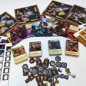 May include: A tabletop board game set with space-themed game boards, cards, and tokens. The game boards feature planets and celestial bodies. Cards display illustrations of characters and scenes. Various tokens and cutouts are also included.