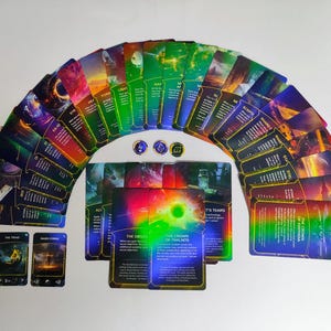 May include: A collection of fantasy-themed playing cards arranged in an arc, featuring vibrant colours and detailed artwork. The cards display various images and text, with three circular tokens. The cards are on a white surface.