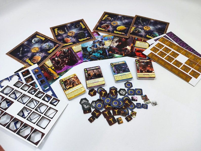 May include: A collection of board game components, including game boards depicting planets, character cards, and various tokens. The color palette includes blues, browns, yellows, and purples, suggesting a space or fantasy theme. The components are arranged on a white surface.