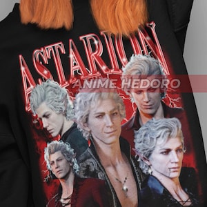 Puede incluir: Sudadera negra con la palabra "Astarion" en rojo, con un gráfico de un personaje con pelo blanco. La sudadera también tiene el texto "ANIME HEDORO" en blanco. La persona de la imagen lleva la sudadera.