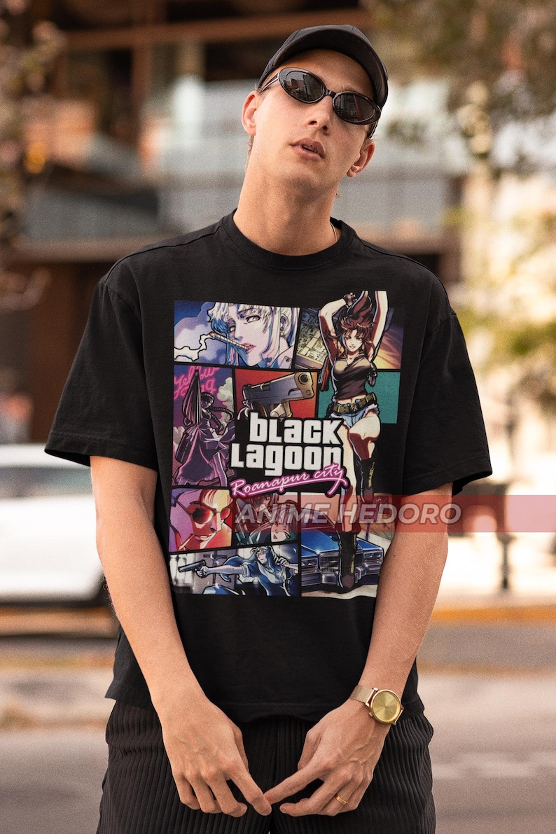 May include: Black t-shirt with a graphic print of characters from the anime Black Lagoon. The graphic includes the text "Black Lagoon Roanapur city" and "Anime Hedoro".