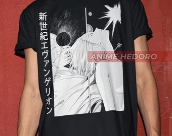 Könnte beinhalten: Schwarzes T-Shirt mit einem weißen Grafikdruck einer Frau, die den Kopf nach hinten geneigt hat und nach oben zu einem hellen Licht blickt. Der Text "新世紀エヴァンゲリオン" ist auf der linken Seite des Grafikdrucks gedruckt.
