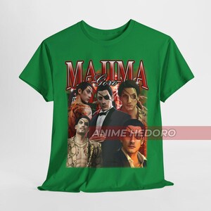 Puede incluir: Camiseta verde con un estampado gr&aacute;fico de personajes del videojuego Yakuza. El texto "Majima Goro" est&aacute; impreso en rojo en la parte superior del gr&aacute;fico. El texto "Anime Hedoro" est&aacute; impreso en blanco en la parte inferior del gr&aacute;fico.