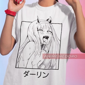 May include: White t-shirt featuring a black and white illustration of an anime character with their tongue sticking out. The text "ANIME HEDORO" and "ダーリン" is printed on the shirt.