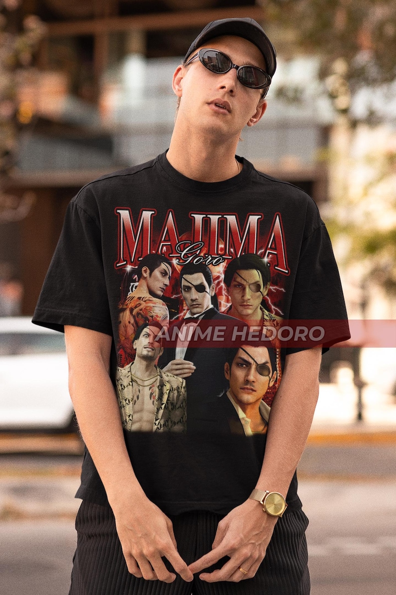 Puede incluir: Camiseta negra con un estampado gr&aacute;fico de un collage de personajes del videojuego Yakuza. El texto "Majima Goro" y "Anime Hedoro" est&aacute; impreso en la camiseta.