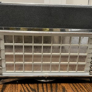 May include: Vintage black and silver radio with a textured top and a silver front panel. The front panel has a grid design and several knobs and switches labeled "VOL", "HIGH", "LOW", "ASF", "FM", "SWT", "SW2", "SW3", "MW", and "LW".