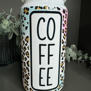 Op de afbeelding: Witte keramische koffiebus met een luipaardprint en het woord "COFFEE" in zwarte letters.