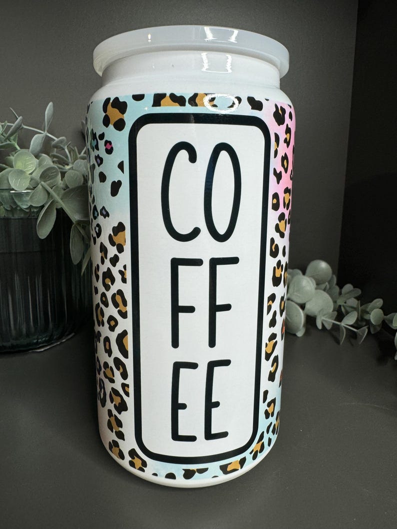 Op de afbeelding: Witte keramische koffiebus met een luipaardprint en het woord "COFFEE" in zwarte letters.