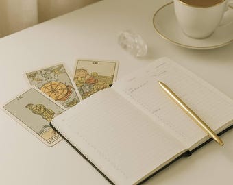 May include: A white table with a gold pen, a notebook, three tarot cards, a crystal, and a white coffee cup with a gold rim on a white saucer. The text "divineseren readings" is at the top of the image. The text "CAREER & LIFE PURPOSE" is at the bottom of the image.