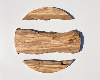 May include: Three pieces of natural wood, cut into a circle, half-circle, and a long rectangle. The wood is a light brown colour with dark brown grain patterns.