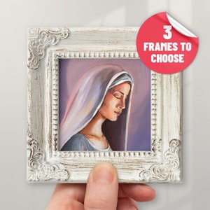 May include: A framed painting of a woman with a veil, wearing a blue dress, with a soft, purple background. The frame is white with a distressed finish.