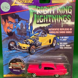 May include: A pink die-cast toy car model of Christine, a 1958 Plymouth Fury, from the movie Christine. The car is on a blue background with the words "Frightning Lightnings" and "Collector Breakthrough! Limited Edition".