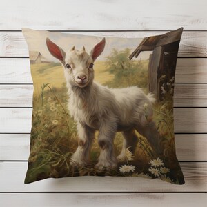 Decorative pillow with a realistic image of a young goat in a field, with a warm, country farmhouse scene in the background, placed on a wooden surface.