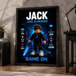 May include: A framed poster featuring a cartoon character in a black hoodie with a blue J, holding a glowing blue sword. The text reads JACK, LEVEL 10 UNLOCKED, PLAYER 1, AGE 10, RANK LEGEND, and GAME ON, with icons for XP 2500, WINS 120, and HP 100%.