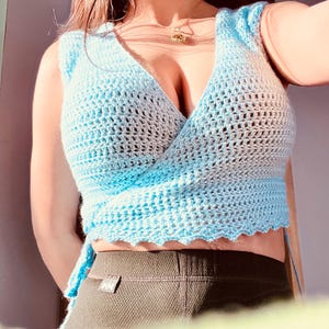 Top cropped azul de crochê com amarração, acabamento em concha, regata sem mangas