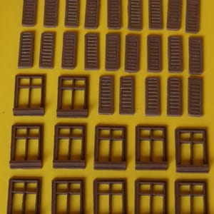 Puede incluir: Una colección de contraventanas y marcos de ventanas de madera marrón. Las contraventanas están cerradas y tienen un diseño de listones. Los marcos de ventanas tienen un diseño sencillo con cuatro paneles de vidrio.