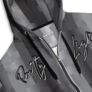 May include: A black and white zippered hoodie with a geometric pattern and the text "Pretty Light" and "Knock Official" printed on it.