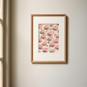 May include: Framed art print featuring a beach scene with pink and white striped umbrellas, beach towels, and small figures of people. The artwork is set against a light beige background, with shadows suggesting sunlight. The frame is made of light brown wood.